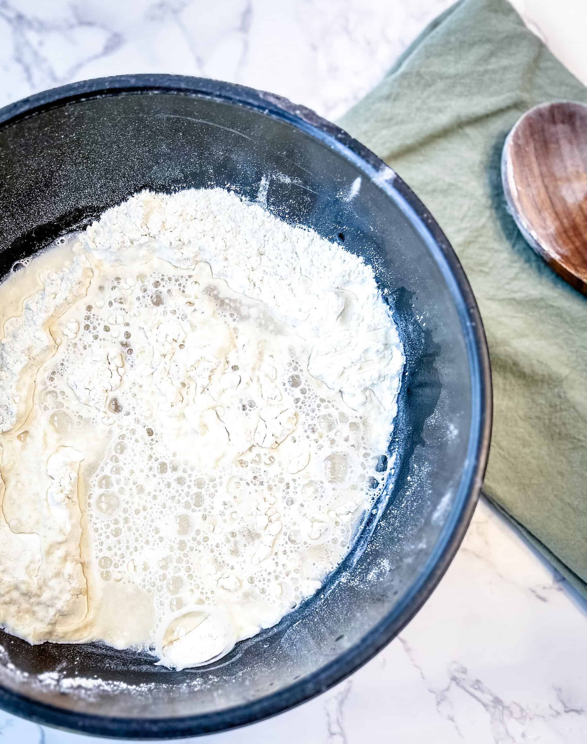 Bread dough with the ingredients combined, ready to be mixed into a ball. 