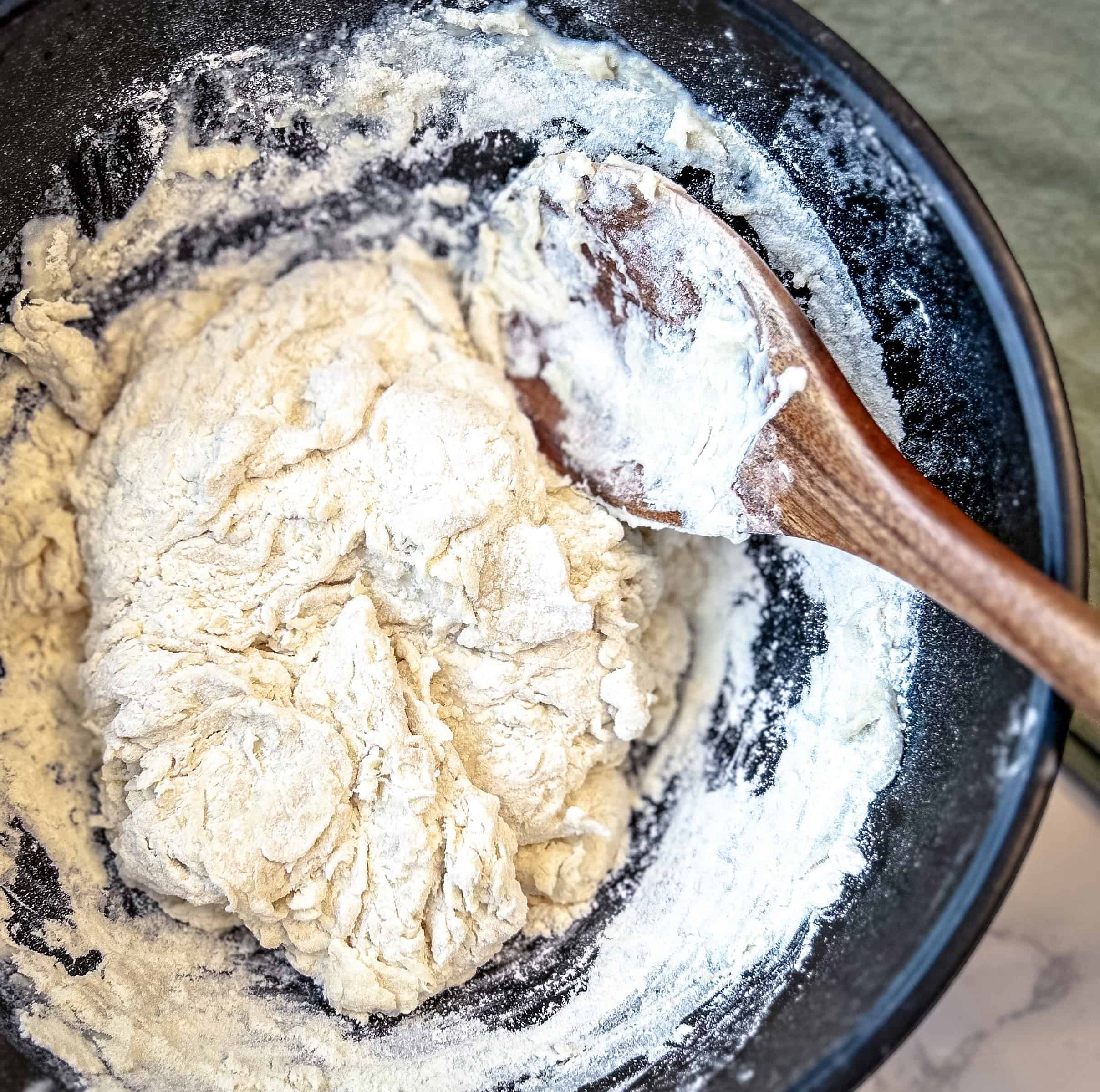 Mixed ingredients shaped into a shaggy ball with a wooden spoon