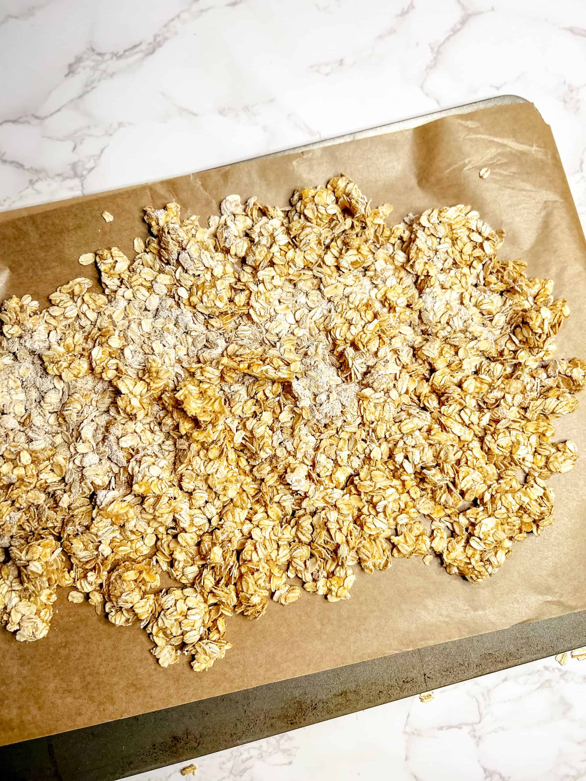 Mixed granola on a baking sheet ready to bake