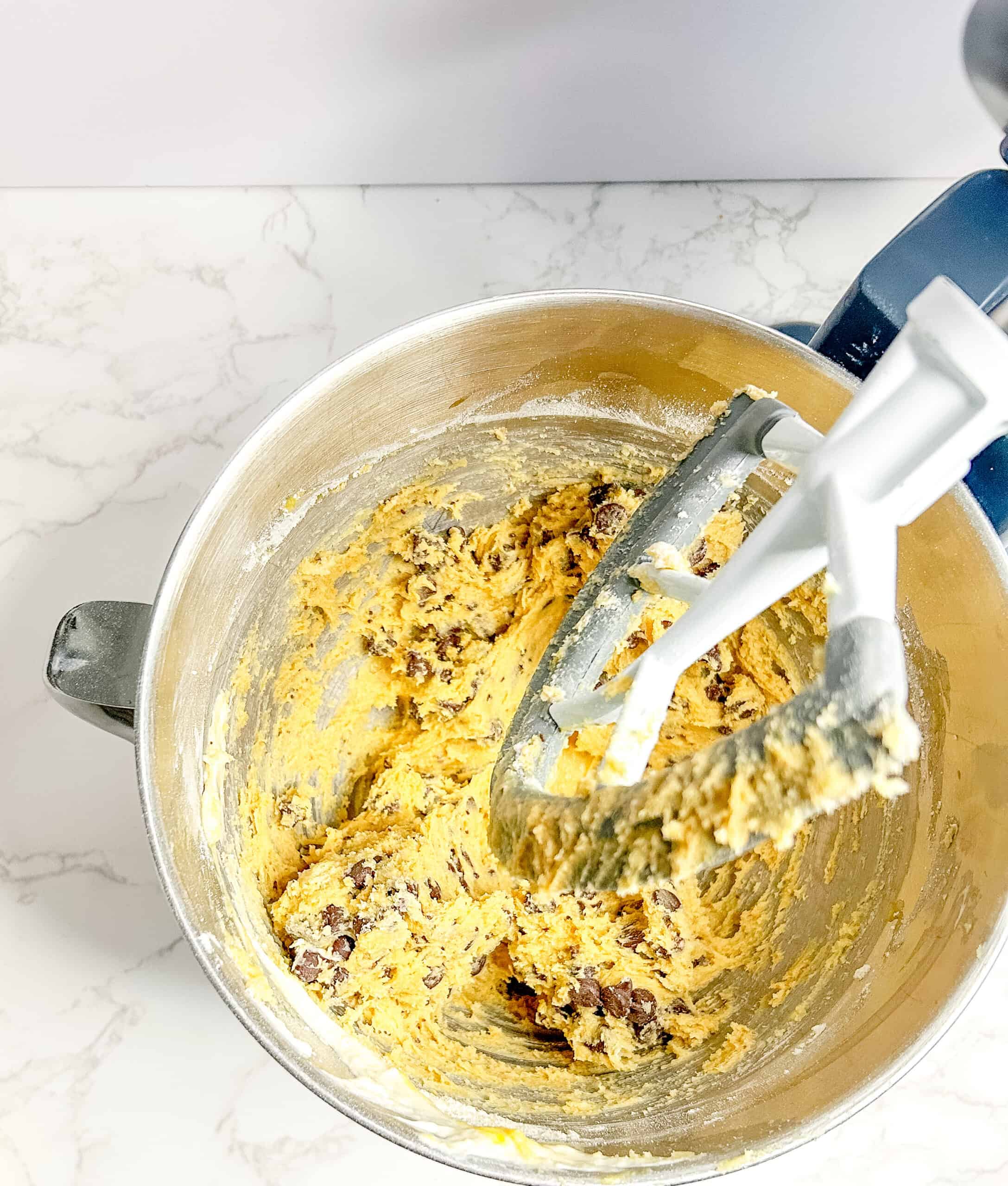 Cookie dough mixed with the flours and the chocolate chips, ready to be shaped and refrigerated