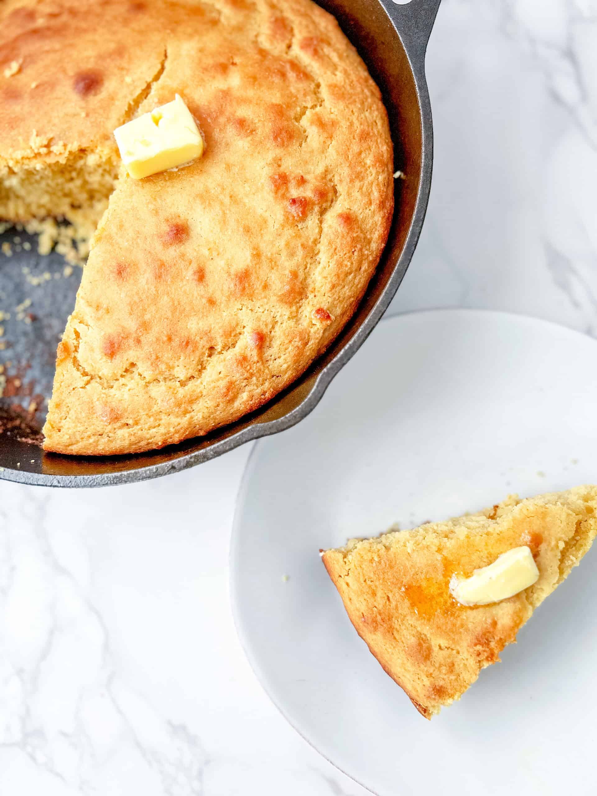 fresh milled flour cornbread sliced on a plate with butter